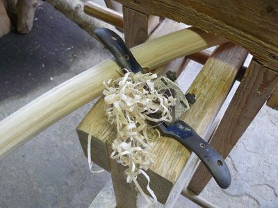 Green Woodworking Spokeshave Tool With A Chair Leg And Wood Shavings On A Shave Horse